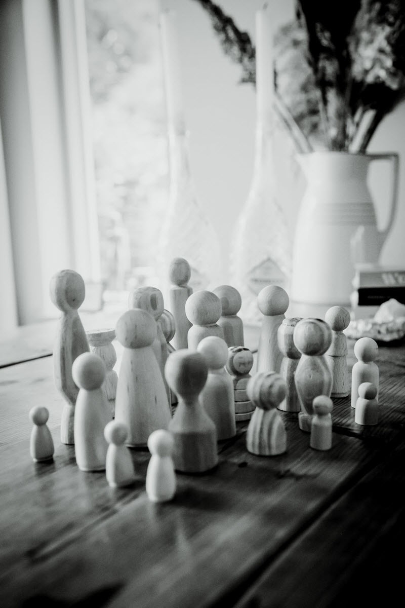 Houten poppetjes in verschillende groottes, symbool voor de generaties binnen een familiebedrijf